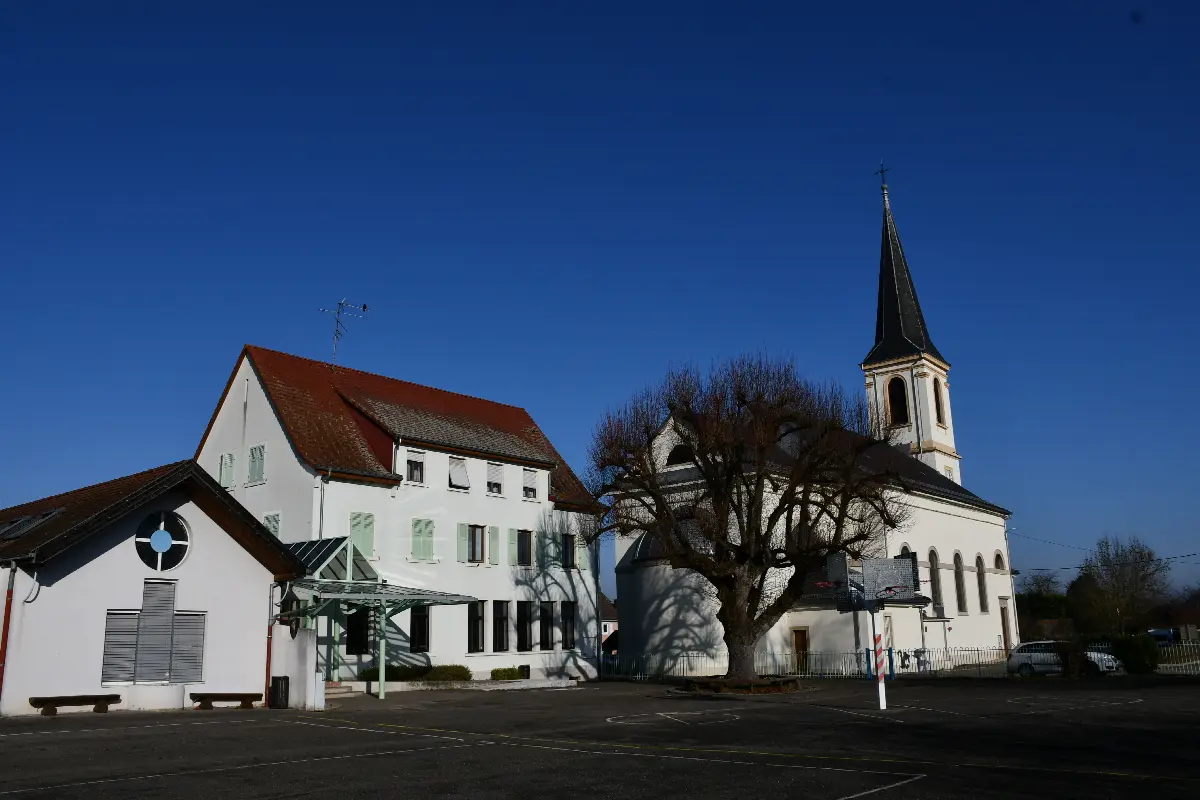 Le site scolaire de Spechbach, place de l'Église : le bâtiment de l'école et le clocher de l'église