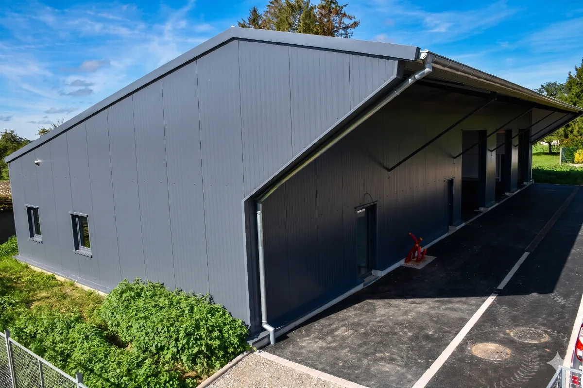 L'atelier municipal de Spechbach, bâtiment technique bardé de gris avec son auvent