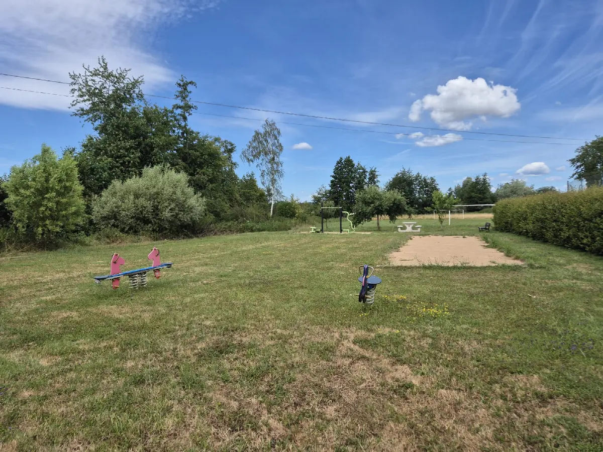 L'espace de détente à côté du terrain de tennis : jeux à ressort, appareils de fitness et terrain de pétanque